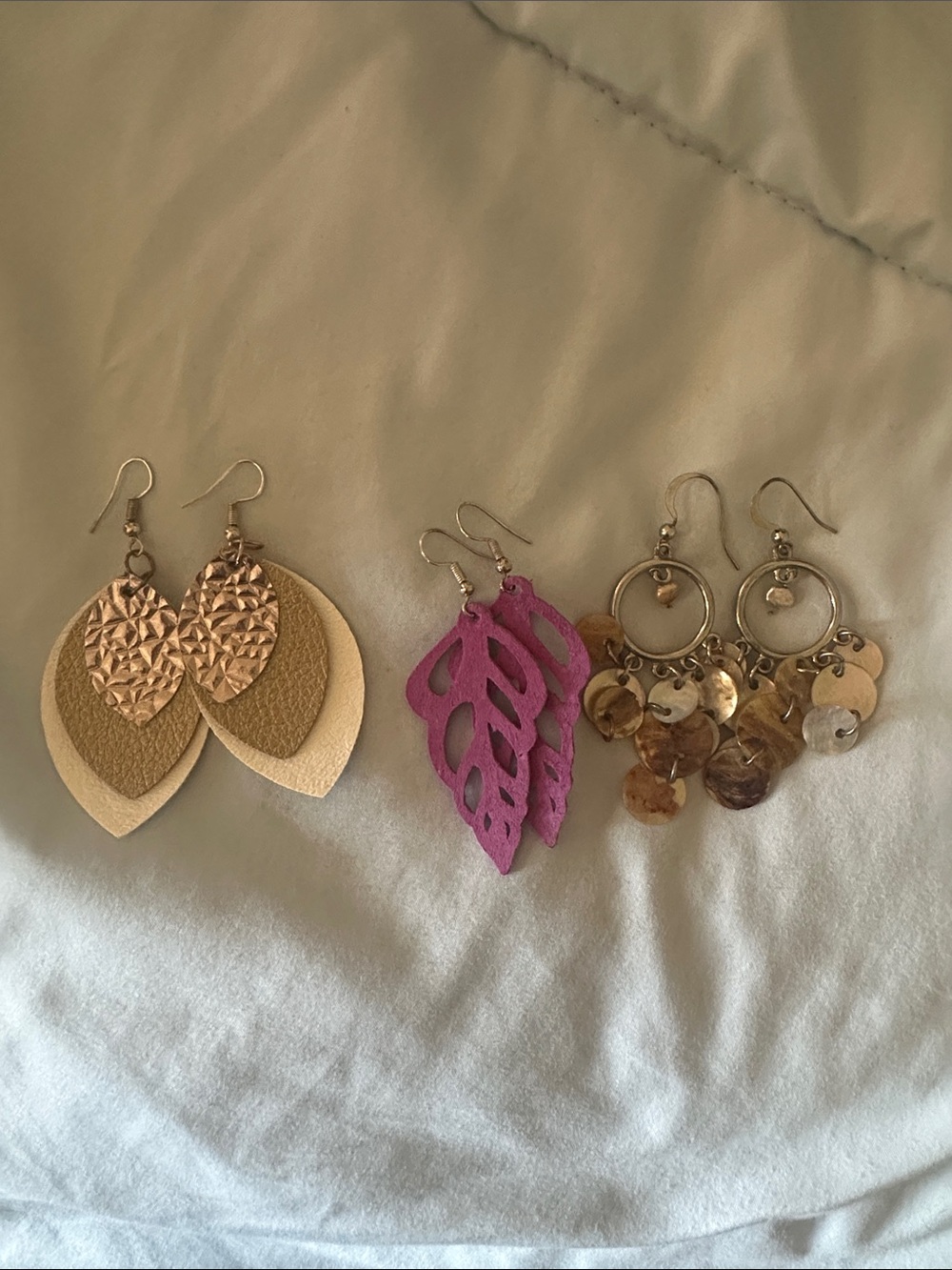 3 sets of earrings dangly and fun! Gold, cream colored and purple